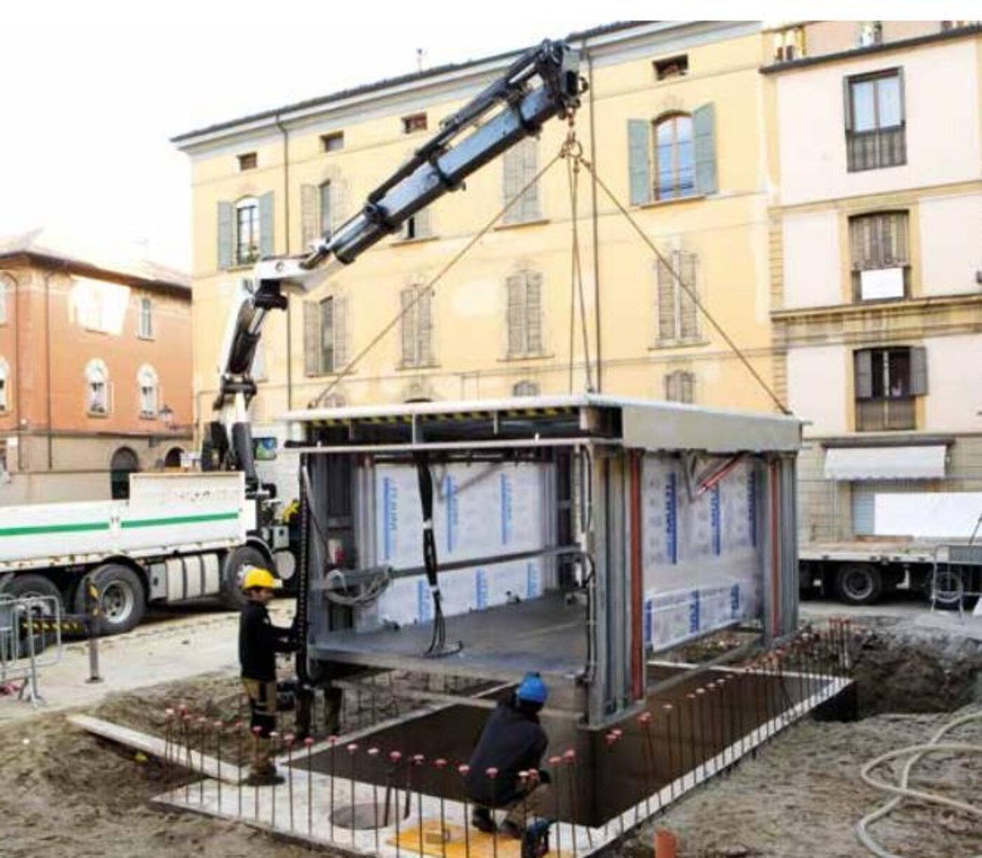 Installazione di un cassonetto interrato con autogru in una piazza italiana